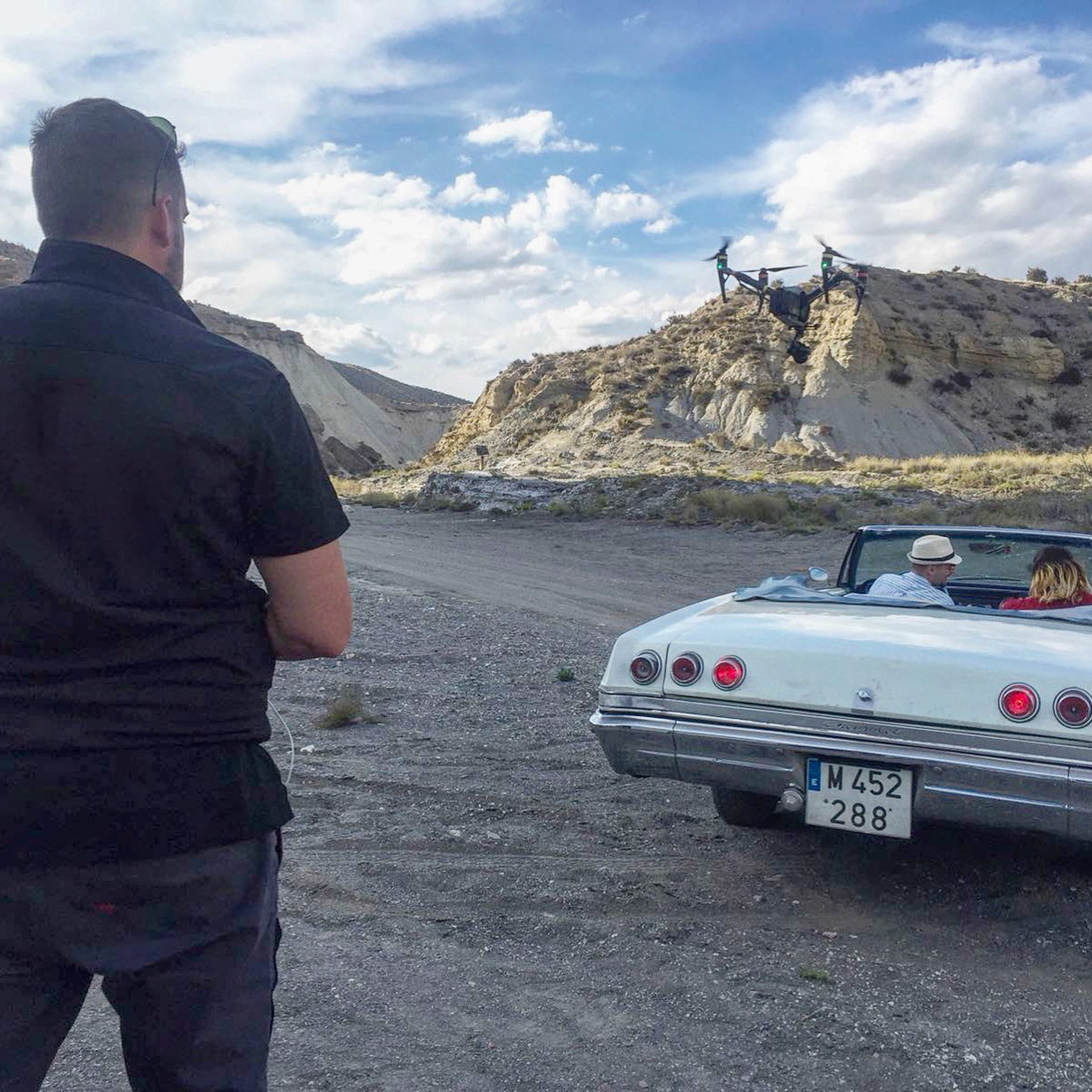 Operador de cámara durante un rodaje con un coche clásico en el desierto de Almería